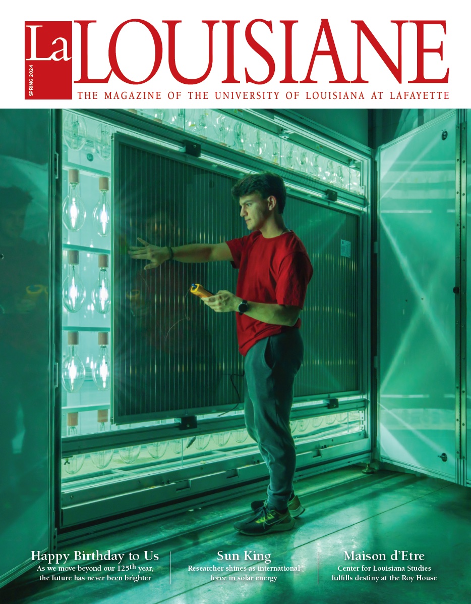 Cover of the spring 2024 issue of La Louisiane magazine with freshman student Wyatt Stoute standing in front of a light-soaking chamber in the solar lab.