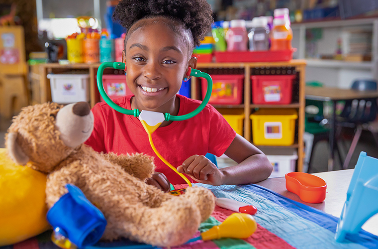 Child playing doctor with a teddy bear at the University of Louisiana at Lafayette Child Development Center