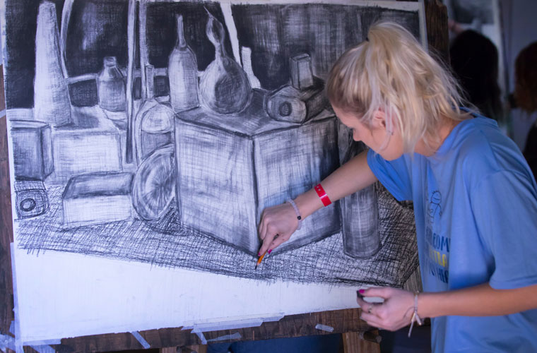 A University of Louisiana art education major sketches with charcoal