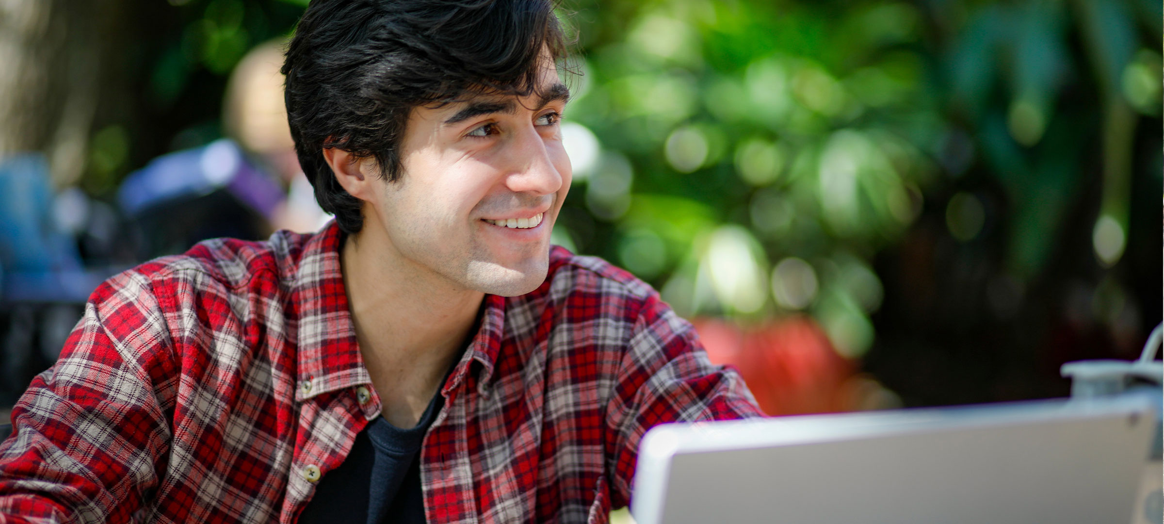 University of Louisiana at Lafayette student smiles while studying in front of his computer