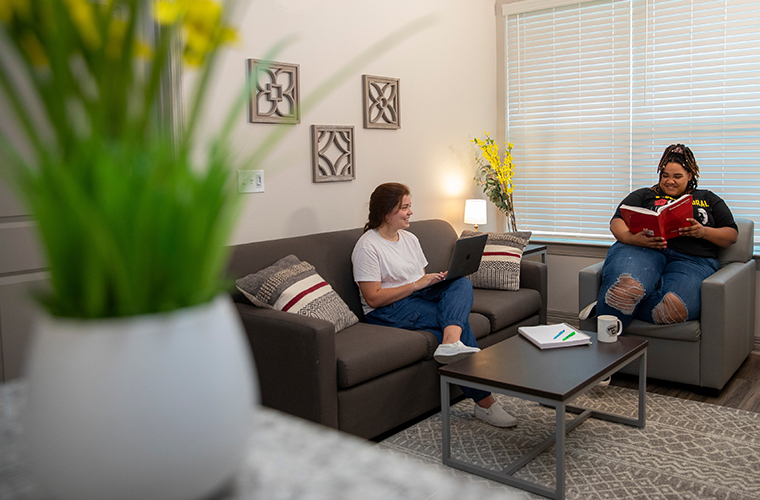 students sit in living room of UL Lafayette residence room