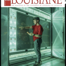 A man standing in front a large cyan light display on the la Louisiane cover