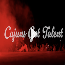 White Caption against a red foggy stage saying, "Cajuns Got Talent"