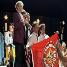 UL Champions pose behind the UL Flag at cajunski nationals